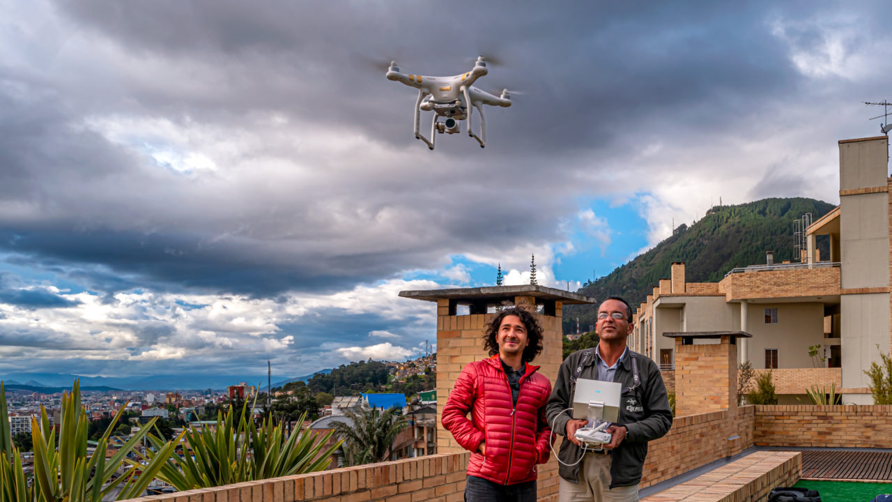 Un par de fotógrafos volando un dron desde la terraza de un edificio en Bogotá